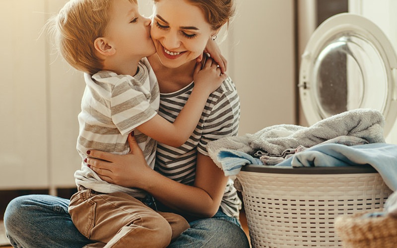 Mom and son having fun while finishing laundry